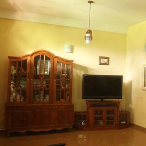 Una televisión o centro de entretenimiento en Sirimal Home Rest