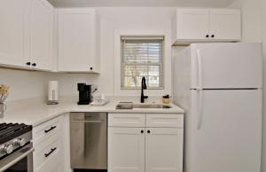 a kitchen with white cabinets and a white refrigerator at The Carolina Wren - Comfort and Convenience in Greenville