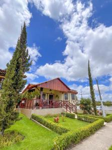 a house with a red roof on a green yard at Chalé Gravatá - Privê Jardim de Marie in Gravatá