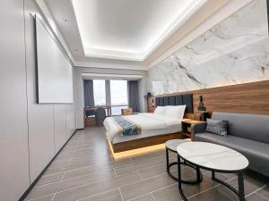 a hotel room with a bed and a couch at Xingyin Cloudy Hotel Guangzhou Changgang Subway Station - Free Shuttle Bus to Canton Fair Complex During Canton Fair Period in Guangzhou