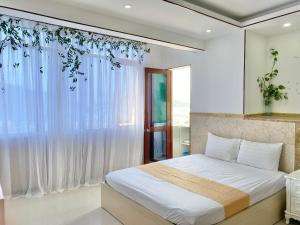 a bedroom with a bed and a window at ZoZo house - Homestay Bai Sau in Vung Tau