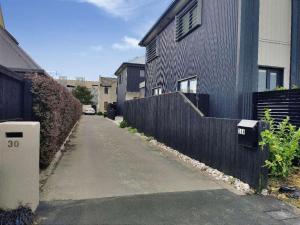 un callejón con una valla al lado de una casa en LilyのHome Elegant Retreat near Riccarton Mall, en Christchurch