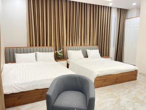 2 Betten in einem Zimmer mit einem Stuhl und einem Stuhl in der Unterkunft Hà Hùng Panorama Hotel in Hà Tiên