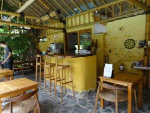 a bar in a restaurant with wooden tables and chairs at Villa Jati Mangsit in Senggigi 