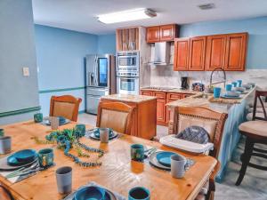 a kitchen with a wooden table with blue walls at Family home sleeps 10! Private yard & king beds! in Dallas