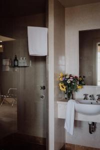 a bathroom with a sink and a vase of flowers at Grande Vue in Hobart