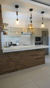 a kitchen with a white counter top and some lights at Casa de Campo in Santa Cruz de la Sierra