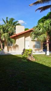 a house with palm trees in front of it at Casa de Campo in Santa Cruz de la Sierra