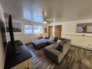 a living room with a couch and a flat screen tv at Newly furnished relaxing stay in Fairbanks