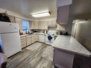 a kitchen with white appliances and wooden floors at Newly furnished relaxing stay in Fairbanks