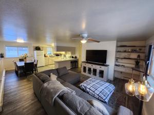 a living room with a couch and a tv and a kitchen at Newly furnished relaxing stay in Fairbanks