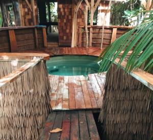 a small pool in a house with a wooden floor at Tukulolo Treehouses in Makaunga