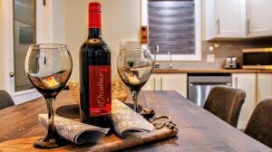 Una botella de vino y dos copas en una mesa. en Chalet Labonté en Mont-Tremblant