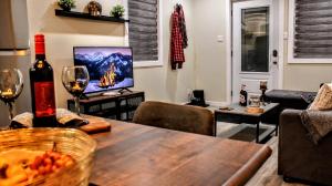a living room with a table and a tv at Chalet Labonté in Mont-Tremblant