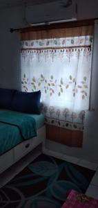 1 dormitorio con cama y ventana con cortina en Mackenzie Guest House, en Clifton