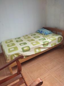 een klein bed in een kamer met een houten vloer bij Hospedaje Camila in Pucallpa