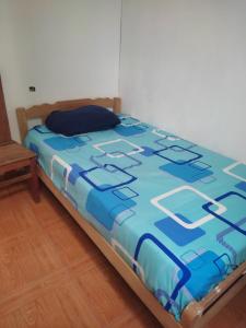 een blauw dekbed op een bed in een kamer bij Hospedaje Camila in Pucallpa