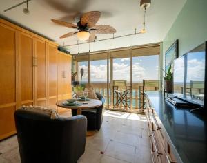 a living room with a ceiling fan and a table at Beachfront Condo in Paradise in Waianae