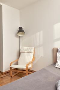 a bedroom with a chair next to a bed at Schönbrunn Palace Apartments FREE Parking and 24h Check-In in Vienna