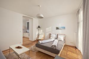 a living room with a bed and a table at Schönbrunn Palace Apartments FREE Parking and 24h Check-In in Vienna
