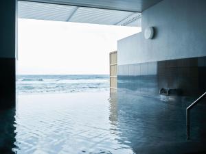 a swimming pool with the ocean in the background at Yunohama Hotel in Hakodate