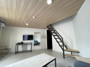 a living room with a spiral staircase and a television at Azana Essence Sanggabuana Bogor in Kamparganya
