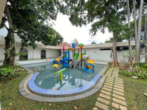 a swimming pool with a playground in a yard at Azana Essence Sanggabuana Bogor in Kamparganya
