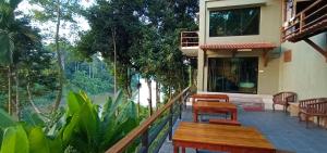 a balcony of a building with tables and chairs at Naura Roomstay in Kuala Tahan
