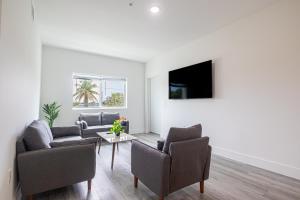 Una sala de estar con un sofá y sillas y una mesa. en Comfy 3 Bed 2 Bath Apt W Free Parki, en Hallandale Beach
