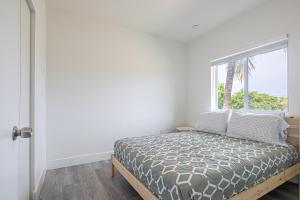 un dormitorio con una cama y una ventana en Comfy 3 Bed 2 Bath Apt W Free Parki, en Hallandale Beach