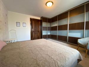 a bedroom with a large bed and a chair at Helska Space by Grand Apartments in Sopot