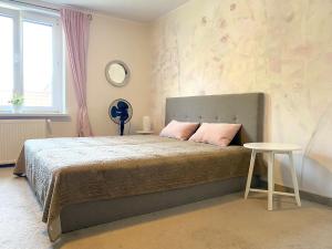 a bedroom with a bed with pink pillows and a table at Helska Space by Grand Apartments in Sopot