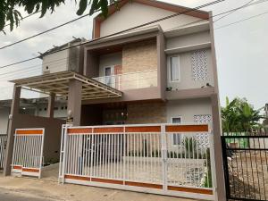 a house with a white fence in front of it at Sumarsi Homestay Mitra RedDoorz in Demangan