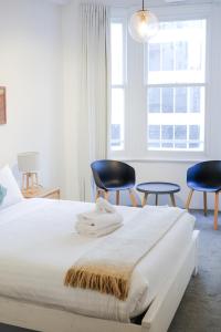 una camera con un letto e due sedie e una finestra di #55highstreetauckland ad Auckland