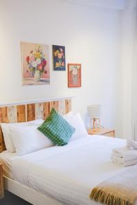 a bedroom with a white bed with a green pillow at #55highstreetauckland in Auckland