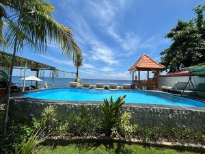 a swimming pool with a view of the ocean at Bahari Beach Amed in Amed