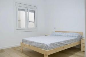- une chambre blanche avec un lit et une fenêtre dans l'établissement Relájate en la Tarragona romana. Recién reformado, à Tarragone