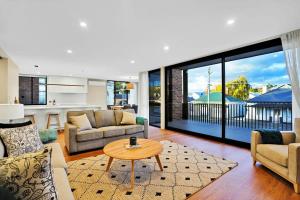 a living room with couches and a table at Stunning Apartment in the CBD with Parking & WiFi in Launceston