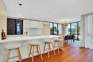 a kitchen with a bar with stools and a table at Stunning Apartment in the CBD with Parking & WiFi in Launceston