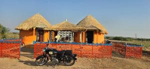 a motorcycle parked in front of a house at Road to Haven chandani in Dholovira
