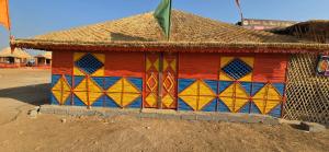 una pequeña casa con una pintura colorida en Road to Haven chandani, en Dholovira