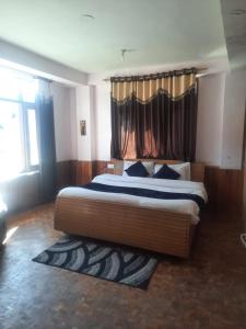 um quarto com uma cama grande e uma cortina em Indraprastha Cottage em Dharmsala