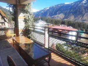 uma varanda com uma mesa e vista para uma montanha em Indraprastha Cottage em Dharmsala