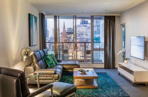 a living room with a couch and a table at Quay West Suites Melbourne in Melbourne