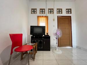 een woonkamer met een ventilator en een televisie bij Alan's Homestay in Kuripan