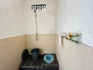 a small bathroom with a shower and a toilet at Alan's Homestay in Kuripan