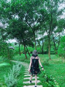 a woman walking down a path in a park at CĂN KITE- CÁNH DIỀU ( MOON VLLA SÓC SƠNI in Hanoi