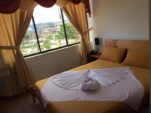 a bedroom with a bed with a large window at Hotel Shekinah Internacional in Esmeraldas