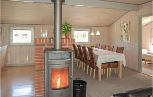 ÅrøsundにあるBeautiful Home In Haderslev With Saunaのリビングルーム(暖炉、ダイニングテーブル付)