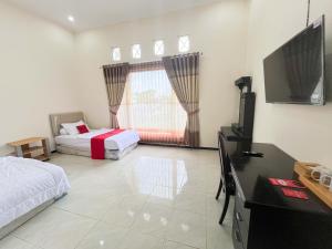 a bedroom with two beds and a flat screen tv at Reddoorz Near BNS 2 in Tlekung